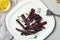 Tasty baked black carrot served on light grey marble table, flat lay