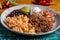 Tasty barbacoa burrito bowl, meat rice black beans sour cream guacamole and chopped vegetables