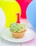 Tasty birthday cupcake with candle, colorful balloons on background