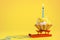 Tasty Birthday cupcake with candle on yellow background with copy space. Delicious muffin on color background.