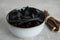 Tasty black candies and dried sticks of liquorice root on grey table