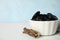 Tasty black candies and dried sticks of liquorice root on white table. Space for text