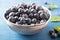 Tasty blueberries in silver bowl on a blue background