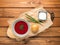 Tasty borsch, onion bun and sour cream on wooden background