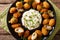 Tasty breaded fried olives with almonds close-up and creamy sauce. horizontal top view