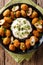 Tasty breaded fried olives with almonds close-up and creamy sauce. Vertical top view