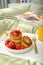 Tasty breakfast in bedroom. Cottage cheese pancakes with strawberries and honey on white tray