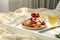 Tasty breakfast served in bedroom. Cottage cheese pancakes with fresh berries and icing sugar on wooden tray