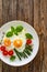 Tasty breakfast. Sunny side up eggs with cooked green asparagus and fried tomatoes served on wooden table