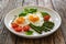 Tasty breakfast. Sunny side up eggs with cooked green asparagus and fried tomatoes served on wooden table