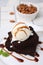 Tasty brownies served with ice cream and caramel sauce on table, closeup