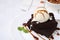 Tasty brownies served with ice cream and caramel sauce on white tiled table, closeup. Space for text