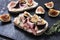Tasty bruschetta with cream cheese, proscuitto and figs