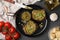 Tasty bruschettas with pesto sauce and ingredients on dark grey table, flat lay