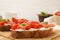 Tasty bruschettas with prosciutto, tomatoes and cheese on wooden board, closeup