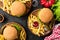 Tasty burgers, cheeseburgers, french fries, salad and red plaid kitchen textile