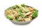 Tasty Caesar salad with pasta in bowl on white background