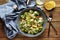 Tasty Caesar salad with pasta in bowl on wooden table