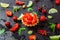 Tasty cake basket with strawberries and cream on a black background with berries currants, gooseberries, cherries, lime slices and