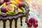 Tasty cake decorated with chocolate glaze and fruits (half cake)