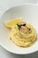 Tasty capellini with mussels and lemon on plate, closeup. Exquisite presentation of pasta dish