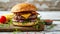 Tasty Cheeseburger with herbs on white wooden table