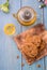 Tasty chocolate chip cookies stacked on a board served with tea and teapot on blue wooden table.Organic homemade snacks for