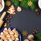 Tasty Christmas cookies, Christmas tree, decorations on black background. Christmas cooking concept. Top view