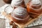 Tasty cinnamon roll with ingredients, coffee on brown table against blue background, closeup