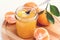 Tasty citrus mandarin jam in a glass jar white background above toned