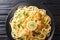 Tasty classic chicken Francaise with spaghetti in lemon wine sauce close-up on a plate. Horizontal top view