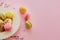 Tasty colorful macarons in vintage plate on trendy pastel pink p