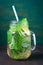 Tasty colourful drink with cold green tea, mint and cucumber in a glass jar on a vintage background