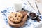 Tasty cookies, bowl with chocolate chips and glass of milk on table