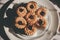 Tasty cookies with jam on top in white plates and hot coffee with window light.