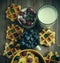 Tasty cornflakes with raspberries and blueberries on blue background. Wafers and milk.