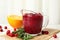 Tasty cranberry sauce in glass pitcher with rosemary and citrus fruit