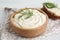 Tasty creamy dill sauce in wooden bowl on table, closeup