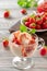 Tasty creamy ice cream with stawberry, poured with sweet syrup in a glass cup on a light background