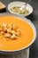 Tasty creamy pumpkin soup with croutons in bowl on table, closeup