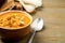 Tasty creamy pumpkin soup with croutons and seeds in bowl on wooden table. Space for text