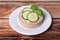 Tasty crispbreads, cucumber, cream cheese and basil on wooden table, closeup