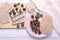 Tasty crispbreads, oatmeal, berries and mint on white wooden table, flat lay