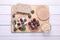 Tasty crispbreads, oatmeal, berries and mint on white wooden table, top view