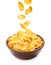 Tasty crispy corn flakes falling into bowl on background. Breakfast cereal