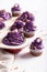 Tasty cupcakes with flower shaped purple cream