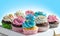 Tasty Cupcakes packaging in delivery box, various cupcakes with pink white and blue cream and colorful sprinkles on blue