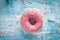 Tasty donut with pink icing and colorful sprinkles