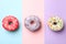 Tasty donuts on three tone background, top view