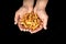 Tasty dried apple slices in male hands on black background